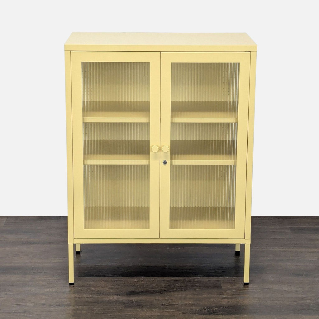Mustard cabinet with powder-coated steel frame, fluted glass doors, sides, and two adjustable shelves.  