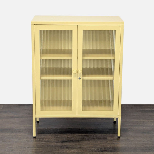 Mustard cabinet with powder-coated steel frame, fluted glass doors, sides, and two adjustable shelves.  