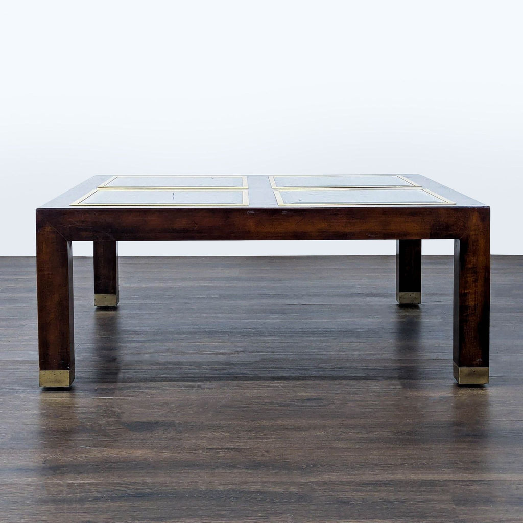 2. Low-profile wood coffee table featuring glass insets and metal accents at the feet.  