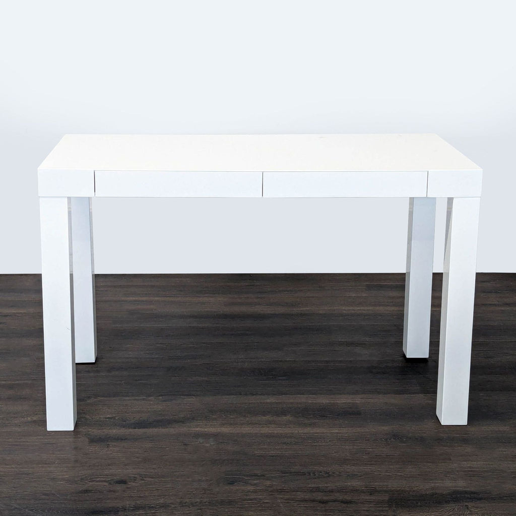 Modern West Elm white desk with minimalist design, two drawers, and sturdy build for versatile home use.  