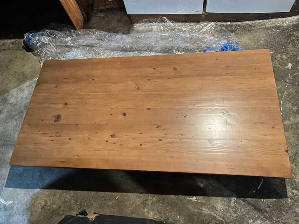 1. Rectangular wooden Reperch dining table with natural grain finish, viewed from above in a garage setting.  