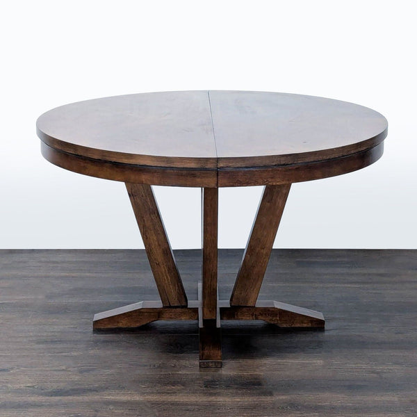Expandable dining table by Legacy Classic, seats 4–6, featuring a saddle brown veneered top.  