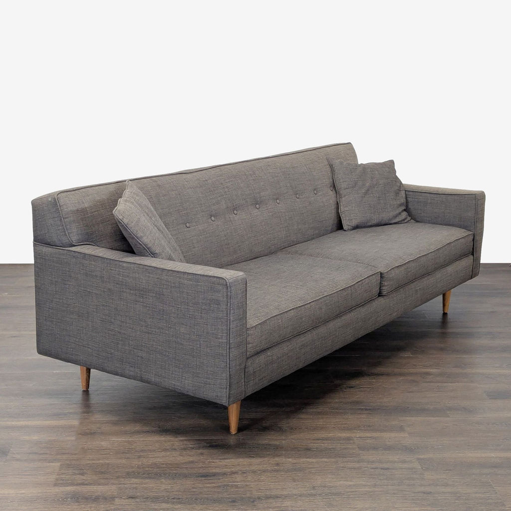 2. Angled view of a stylish gray 3-seater sofa featuring slim arms, comfy cushions, and matching pillows.
