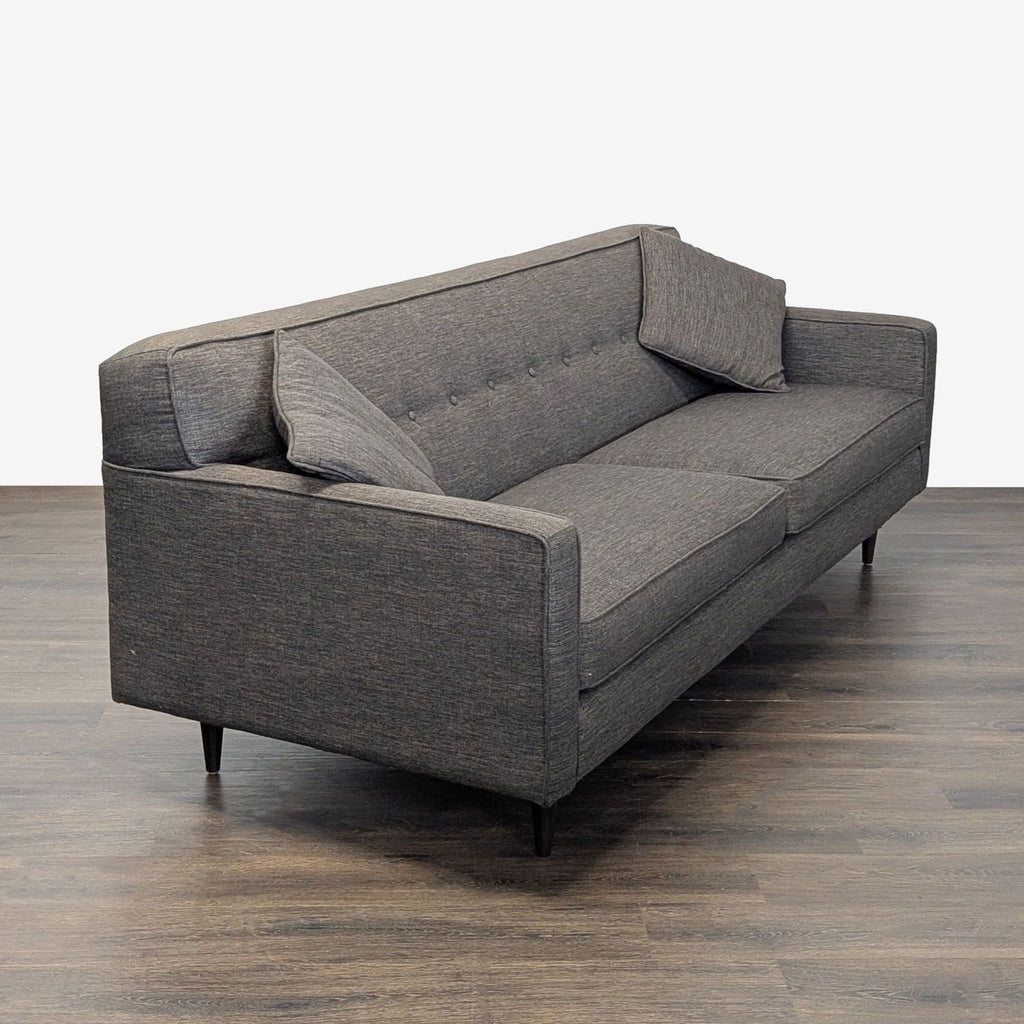 Contemporary 3-seat sofa in dark grey fabric featuring button detailing and two cushions, ideal for living rooms.