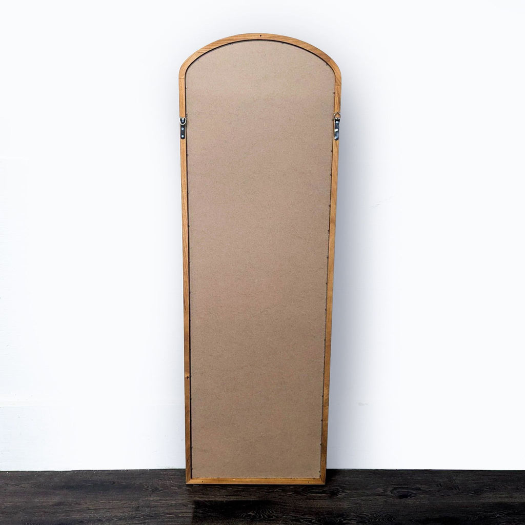 2. Back view of a tall, arched wooden mirror, highlighting the mounting hardware attached to the frame.