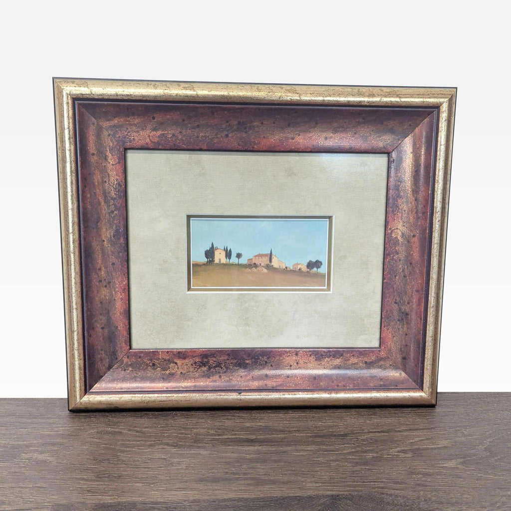 1. Framed countryside landscape print with houses and trees, double matted in a rustic bronze frame.  