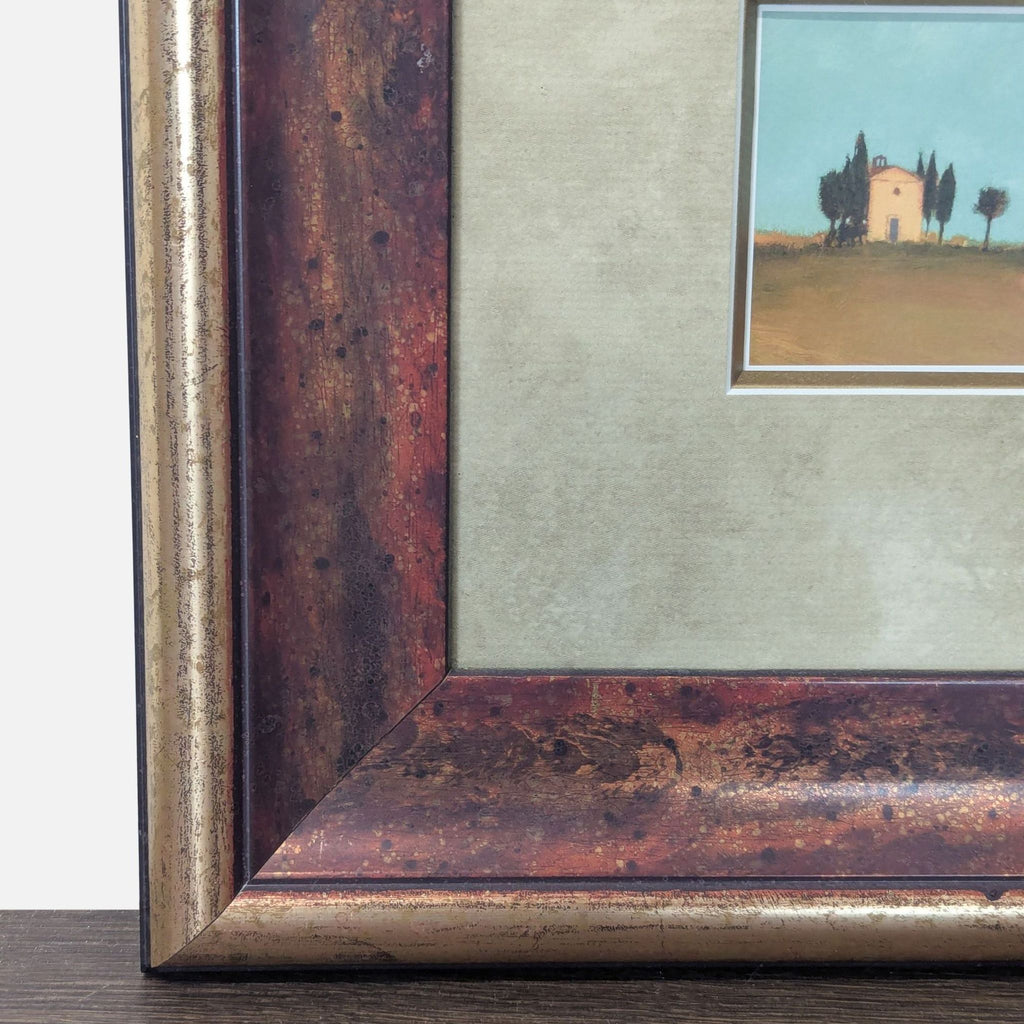 3. Detail of wide, distressed bronze frame surrounding a countryside print, highlighting rustic finish and double matte.