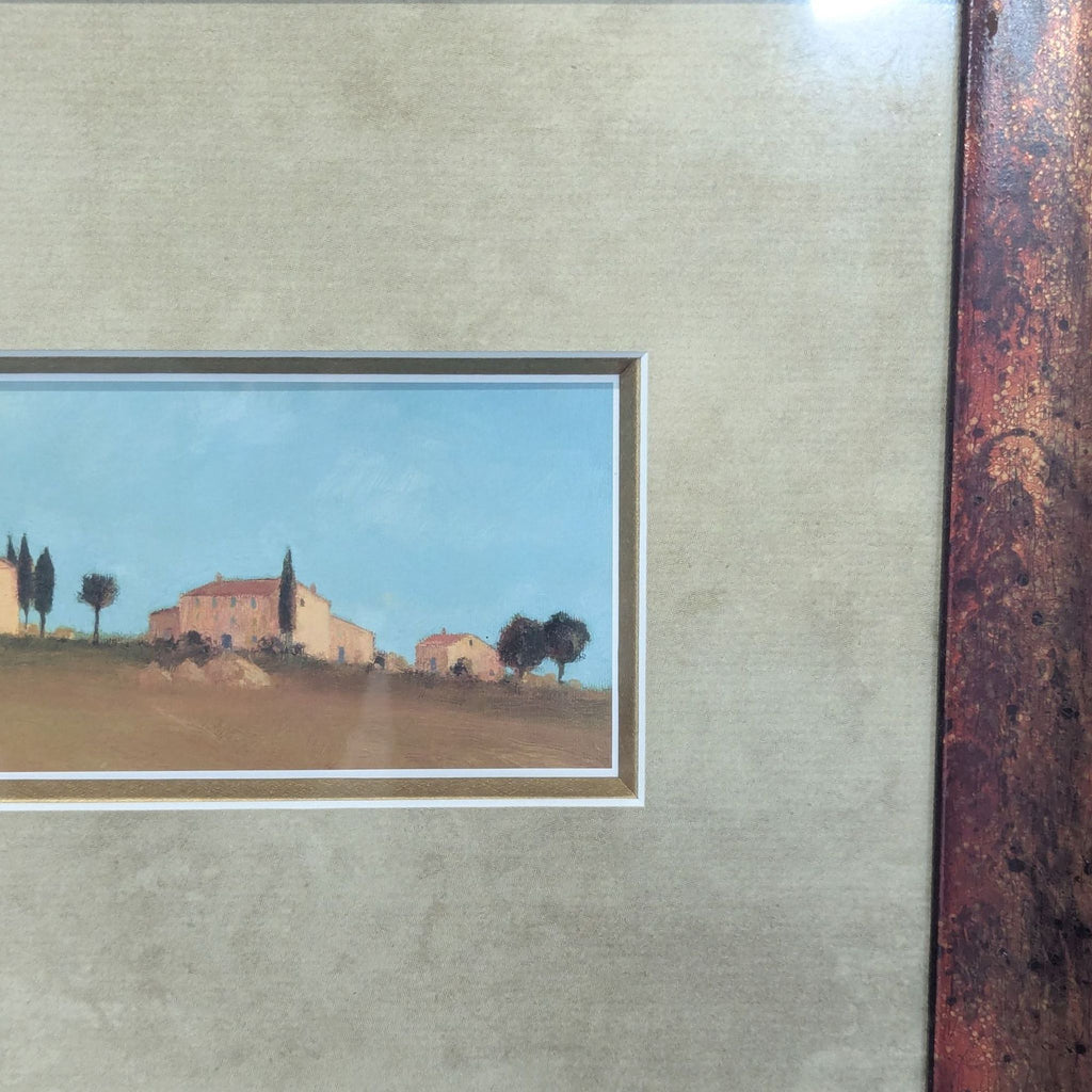 2. Close-up of a peaceful rural landscape print showing homes and trees under a clear blue sky in a matte.  