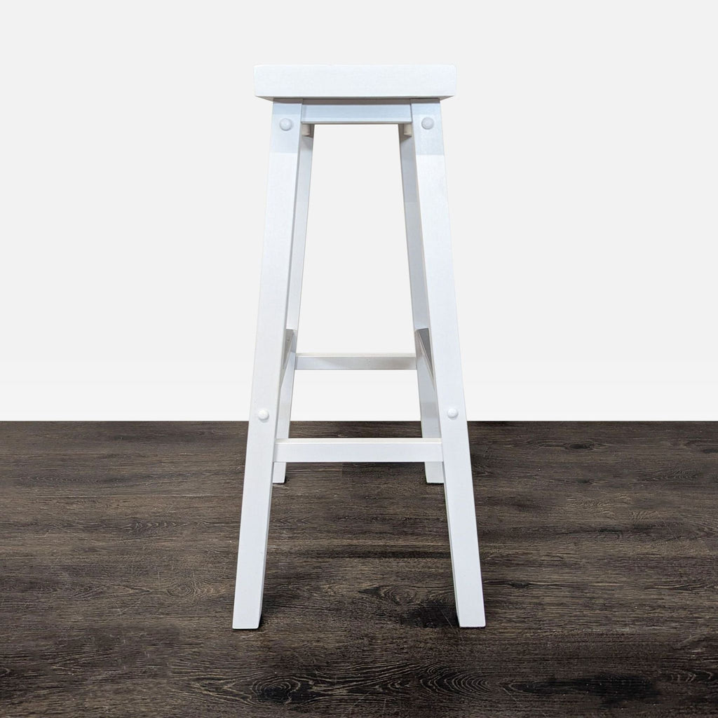 Durable metal ottoman in a simple style, functioning as a sturdy footrest or extra seat.