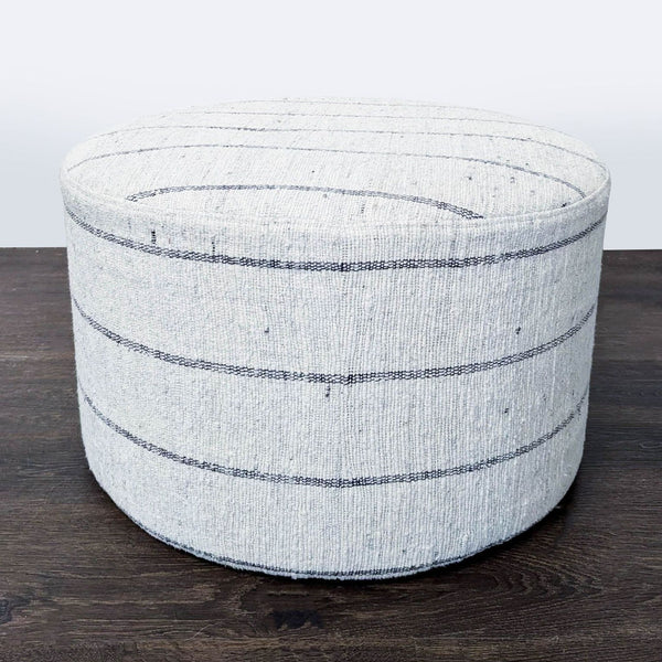 Handwoven cotton ottoman with minimal stripes and textured finish, crafted by artisans in India.