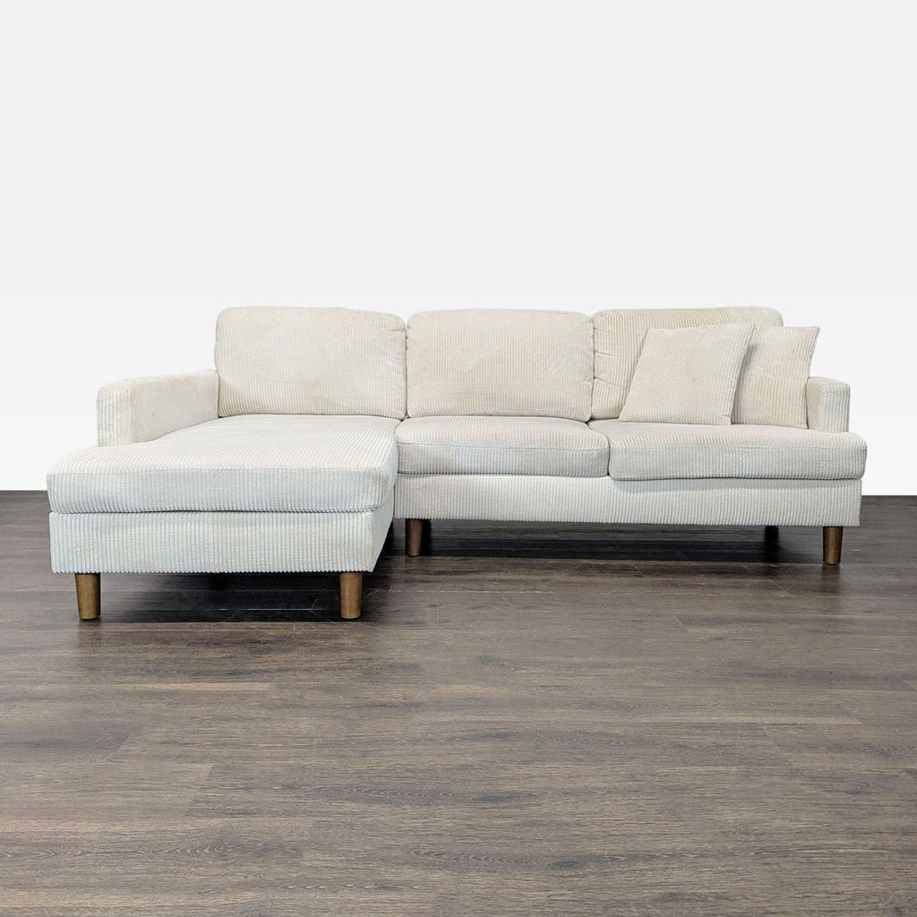 Light beige corduroy sectional with chaise, wooden legs, and cozy cushions, perfect for modern living rooms.