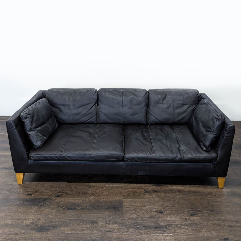 Ikea 3-seat sofa in leather with wooden legs, designed for comfort, easy cleaning, and everyday living.