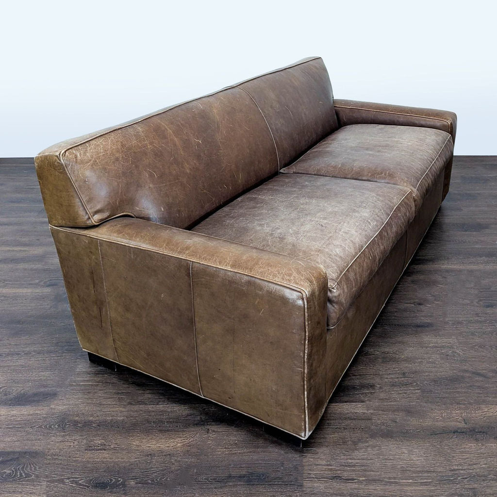 Brown leather Mitchell Gold 3-seater couch featuring sturdy build, comfy seating, and subtle distressed accents.