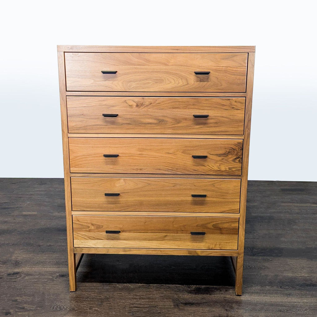 Room and Board dresser with five drawers, natural wood finish, and black handles, shown in a modern setting.