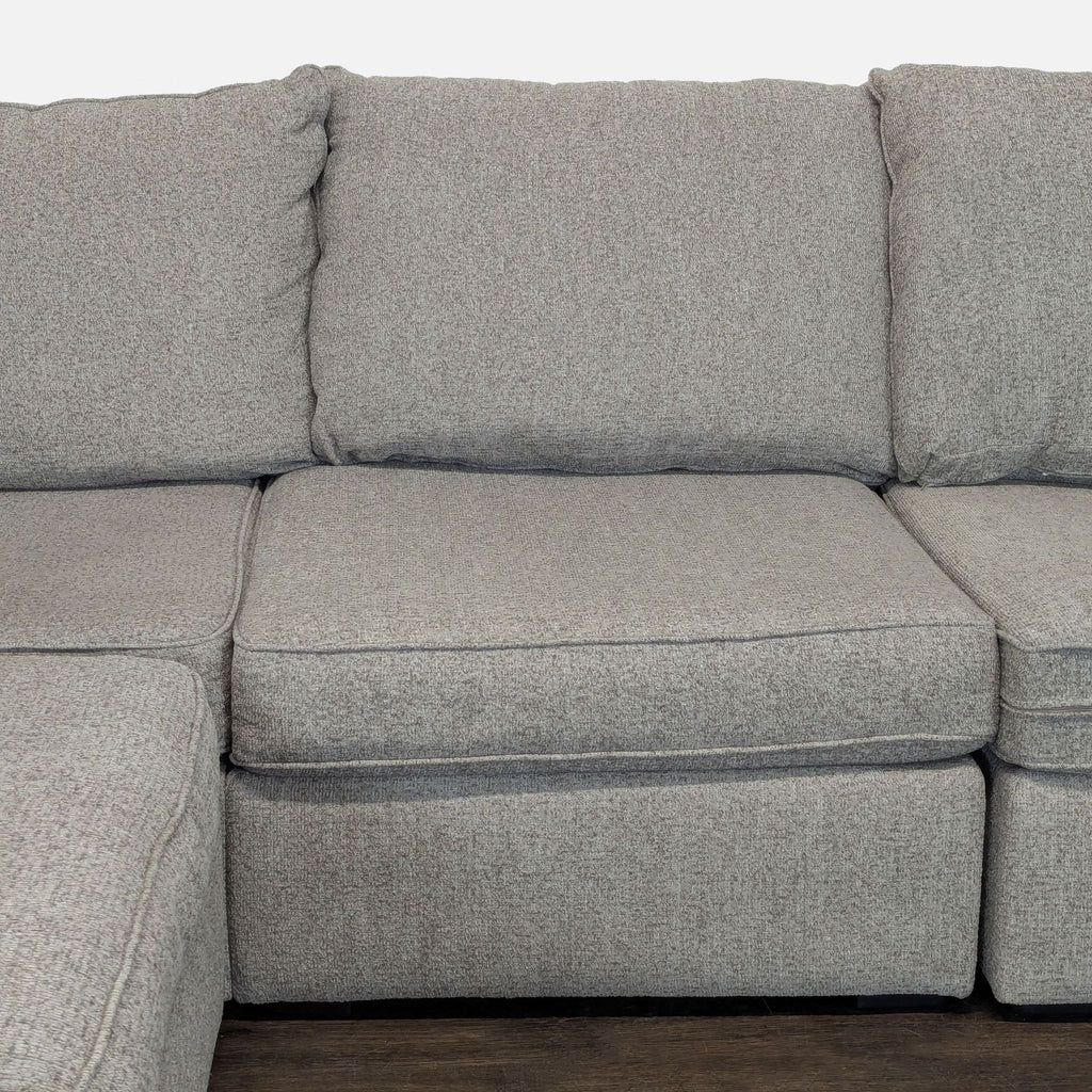 Modern gray sectional couch by Living Spaces, featuring plush seating and durable fabric, perfect for relaxing spaces.