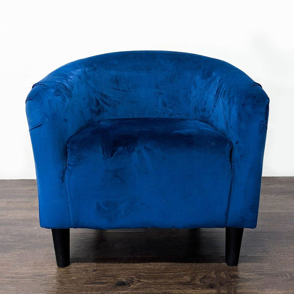 Modern blue velvet lounge chair with curved back and black legs, adding style to any living room.