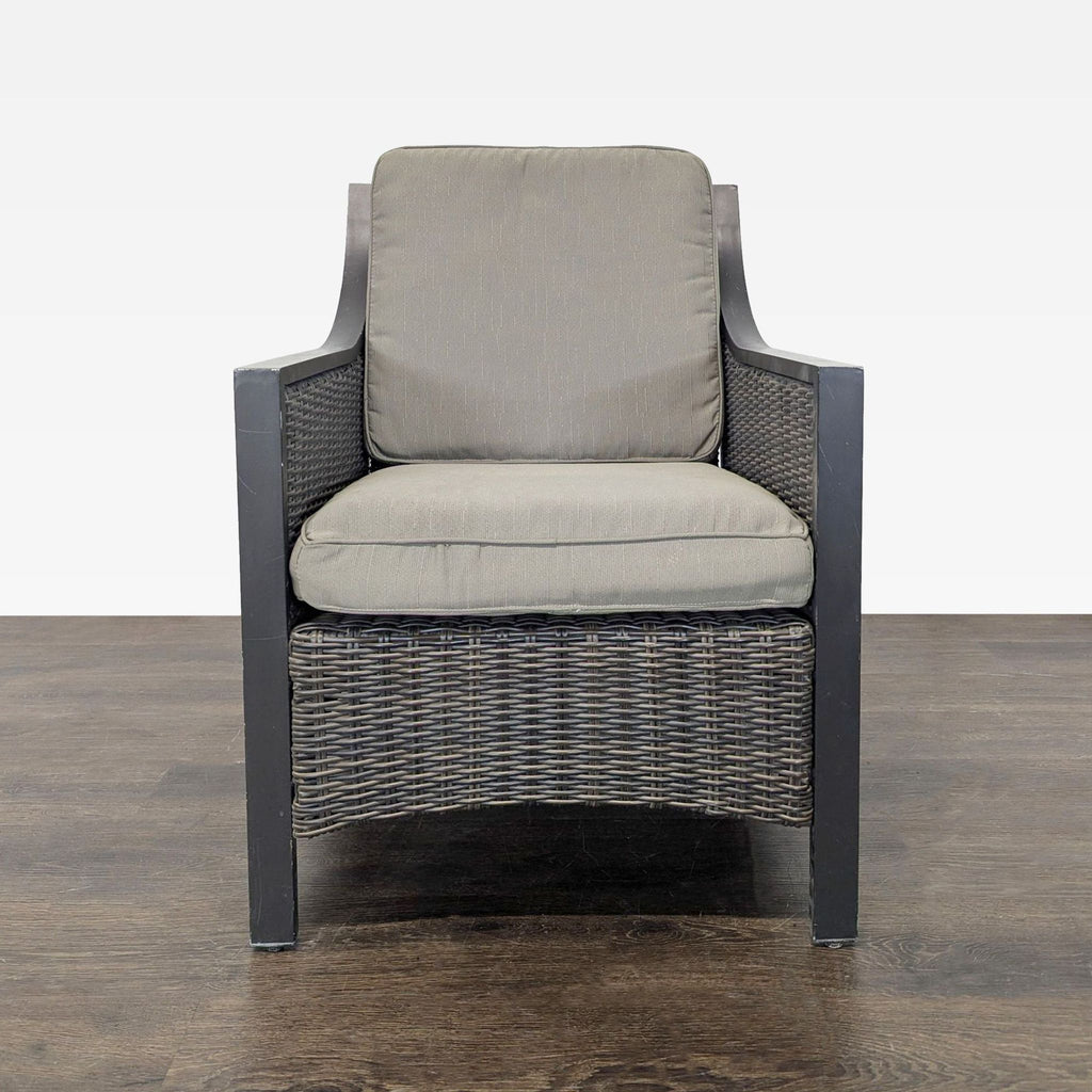 Front view of an armchair with a metal frame, all-weather wicker panels, and removable neutral cushions.