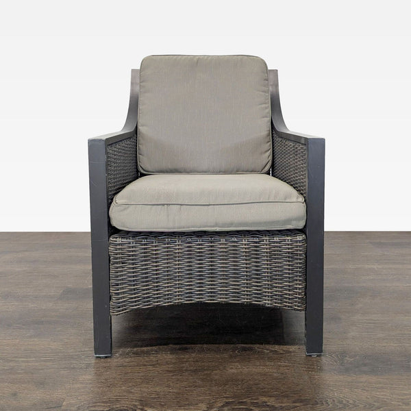 Front view of an armchair with a metal frame, all-weather wicker panels, and removable neutral cushions.