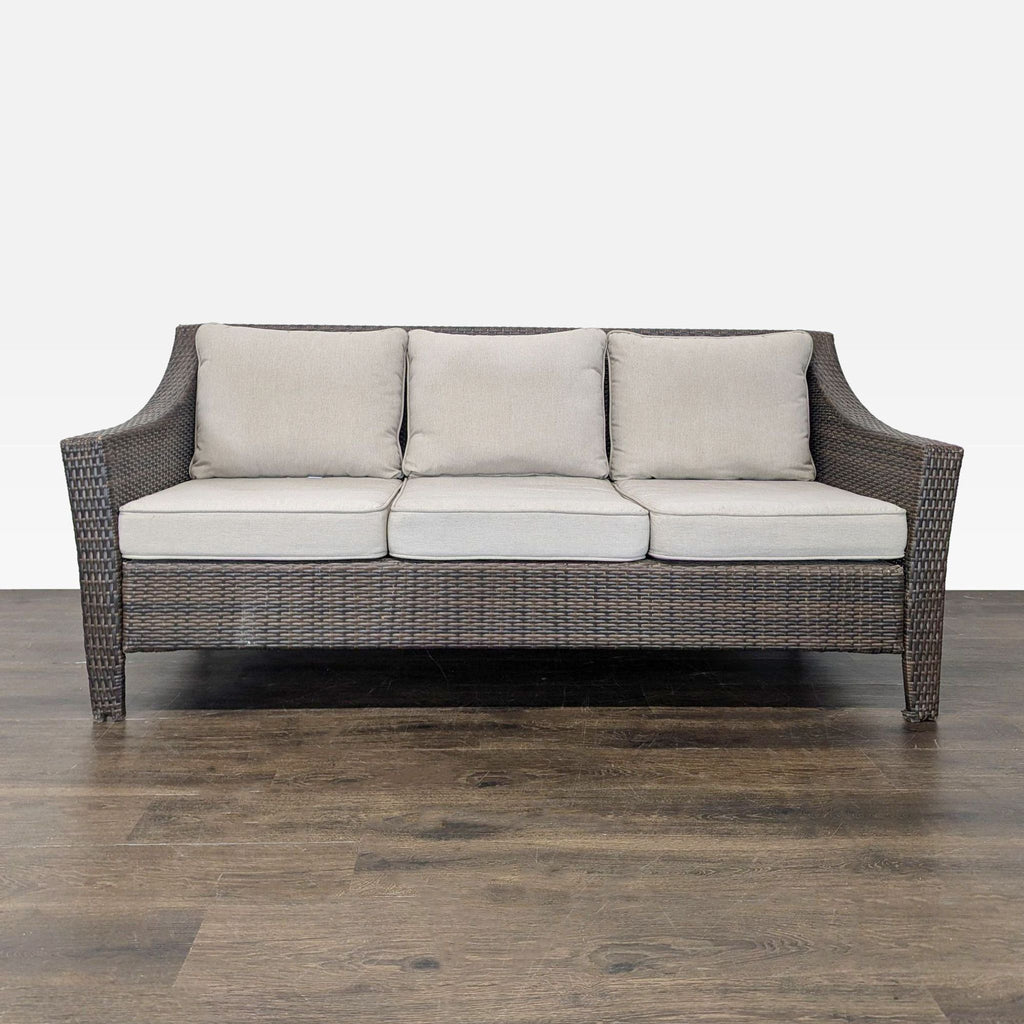 Brown all-weather wicker 3-seater sofa by Threshold with beige removable cushions, shown on wood flooring.  