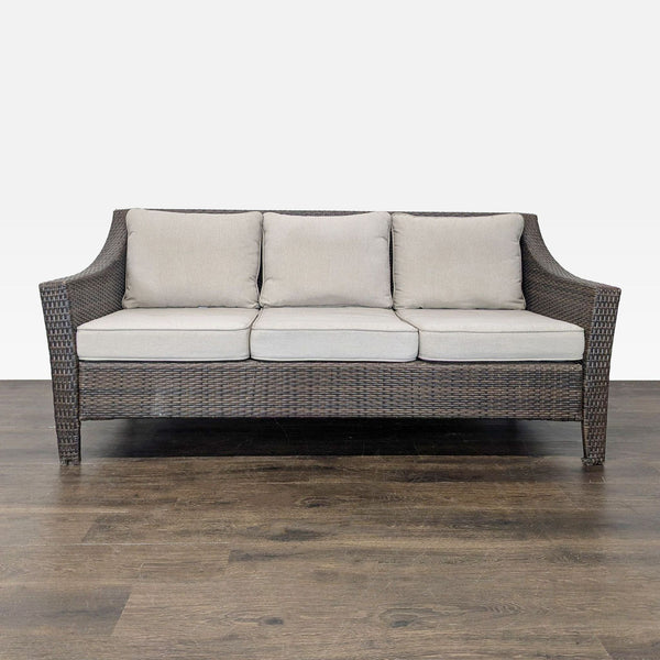 Brown all-weather wicker 3-seater sofa by Threshold with beige removable cushions, shown on wood flooring.  