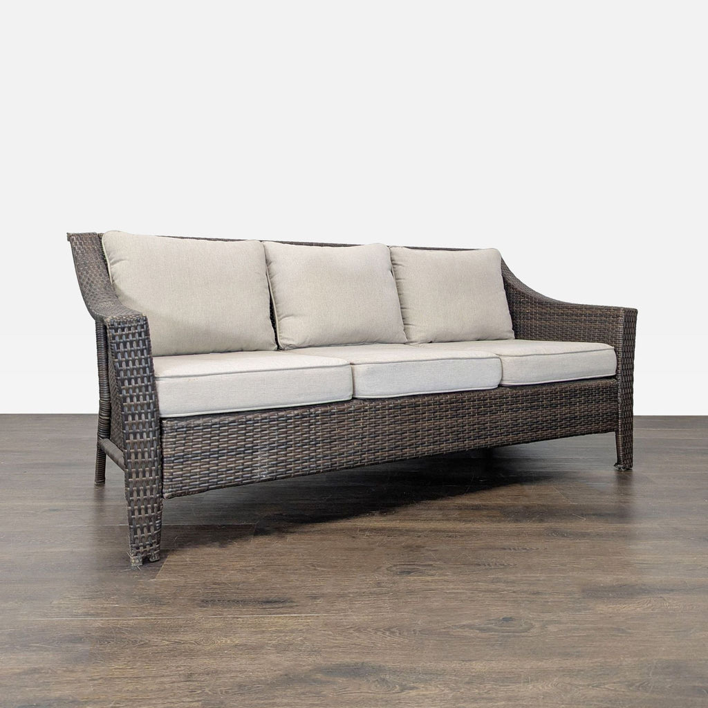 Threshold outdoor sofa featuring sturdy brown wicker frame and plush beige cushions, perfect for patios or gardens.  