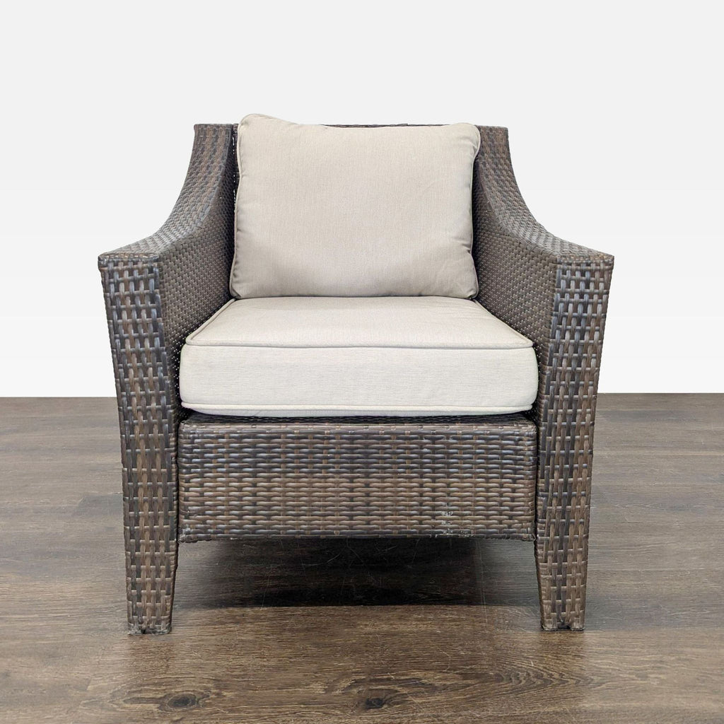 Threshold armchair with brown wicker frame and beige cushions, suitable for indoor or outdoor use.