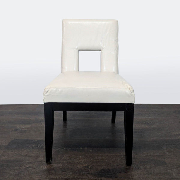 1. Modern ivory dining chair from Pier 1 Imports with a cutout backrest and dark wooden legs, front view.