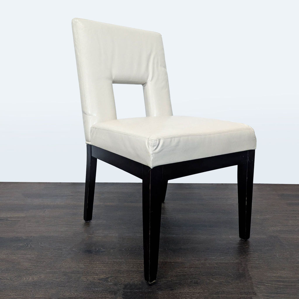 2. Pier 1 Imports dining chair in ivory faux leather with a square cutout back and black legs, angled view.
