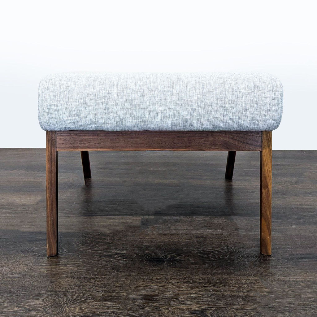 Modern black walnut ottoman featuring an ergonomic shape, designed by Article for versatile seating.  