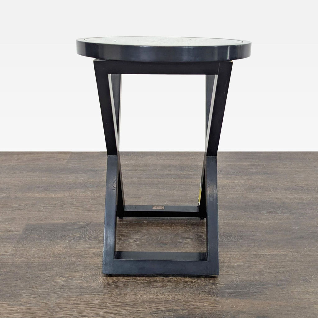 1. Modern black end table with a round top and geometric base, shown against a wood floor.