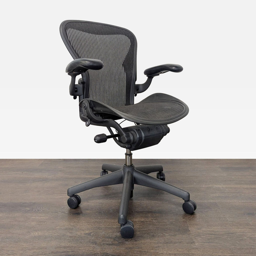 Black ergonomic Herman Miller chair featuring a mesh seat, adjustable height, and smooth-rolling casters.