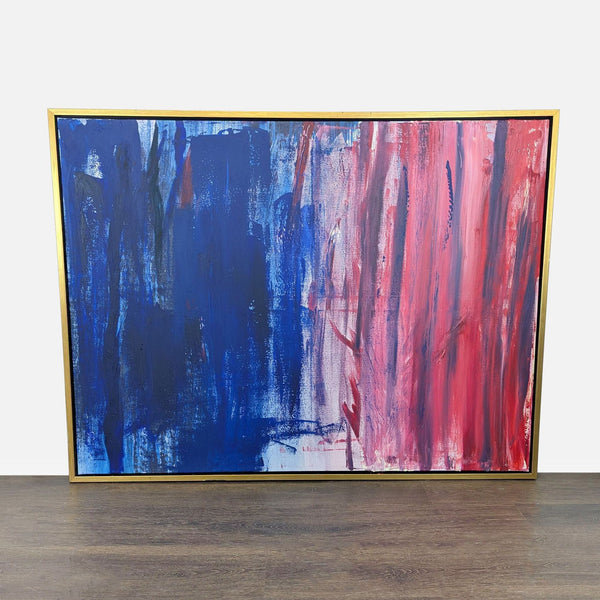 Abstract canvas art with dynamic blue and red brushstrokes, gold frame, by Vybe Interiors.  