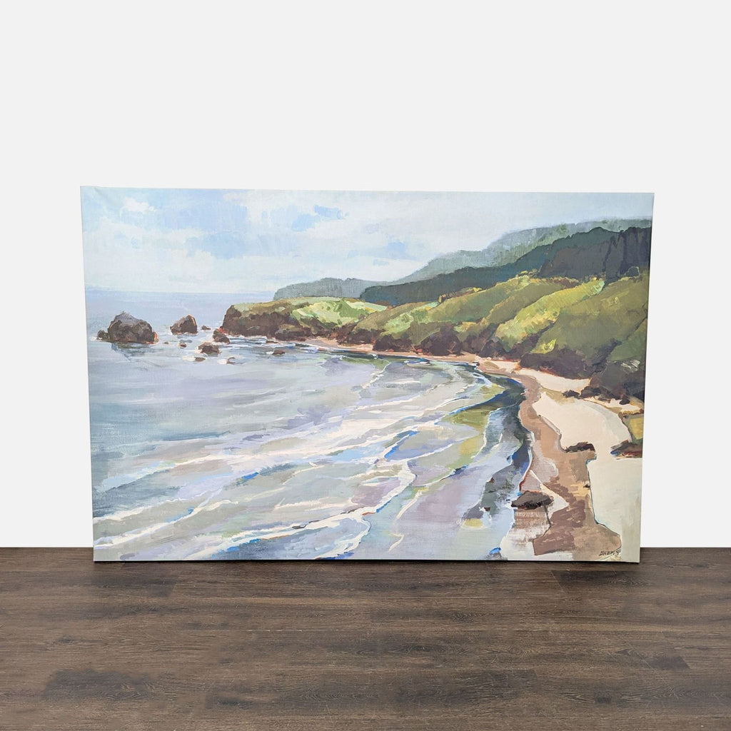 1. Framed coastal landscape print showing sandy shore and green hills, by Giantart.com, on a wooden floor.
