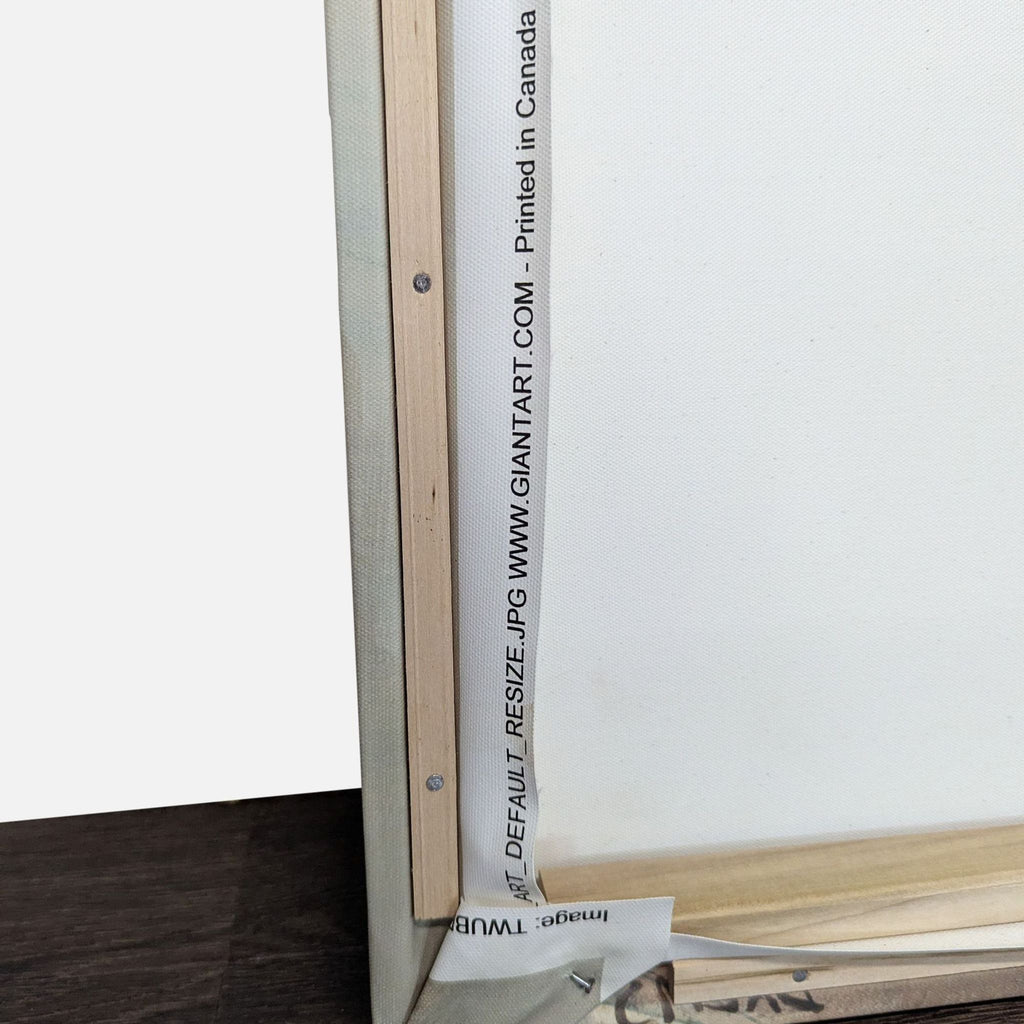 3. Rear view of a canvas print with visible wooden frame and Giantart.com branding printed on the edge.