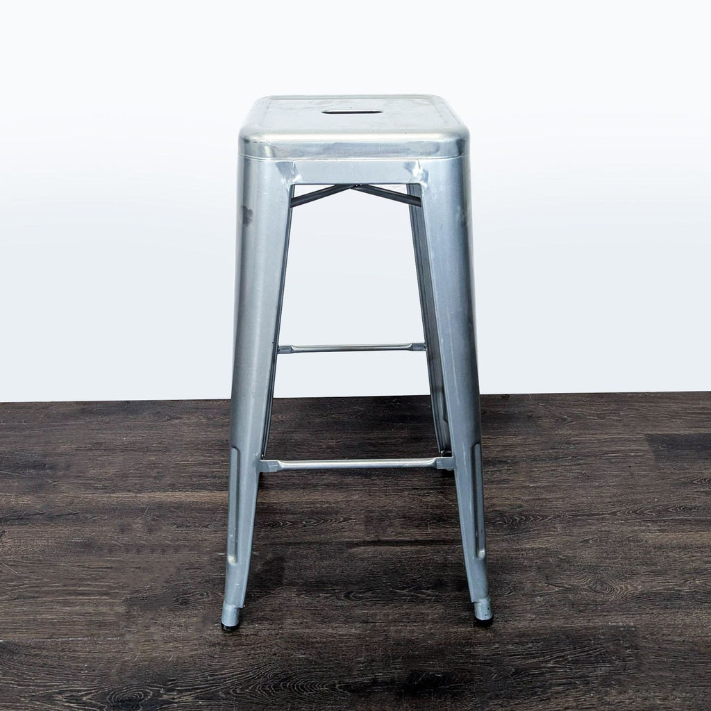 1. Stackable metal bar height stool with a square drain seat, designed for indoor or outdoor use.  