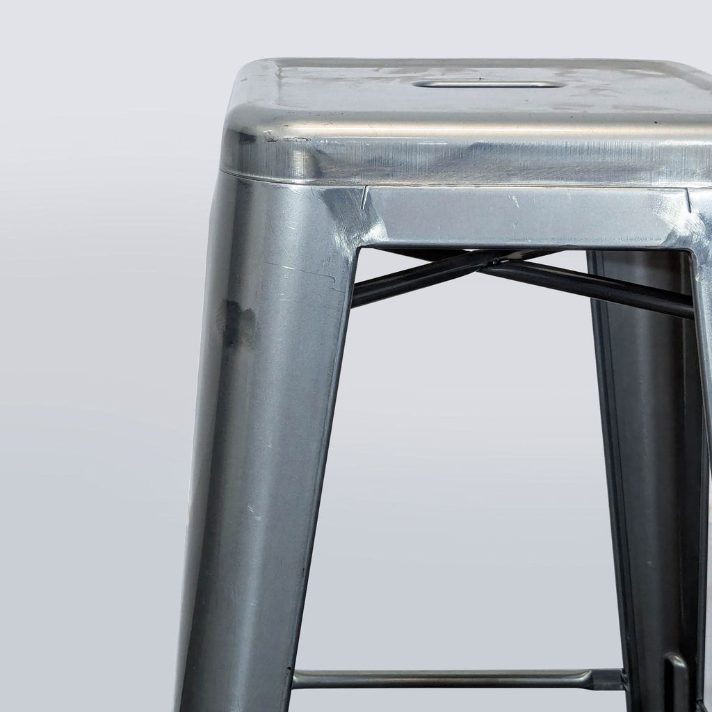 3. Close-up of a metal stackable bar stool showing the durable square drain seat and reinforced frame.