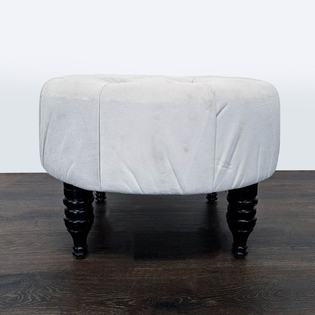 1. Round light grey ottoman with tufted top and dark wooden legs, placed on a wooden floor.