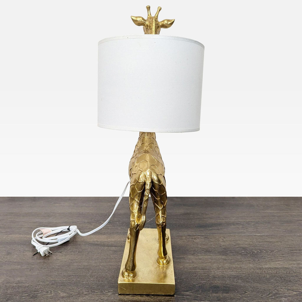 Sculpted gold giraffe lamp base paired with a classic white shade, perfect for stylish lighting needs.