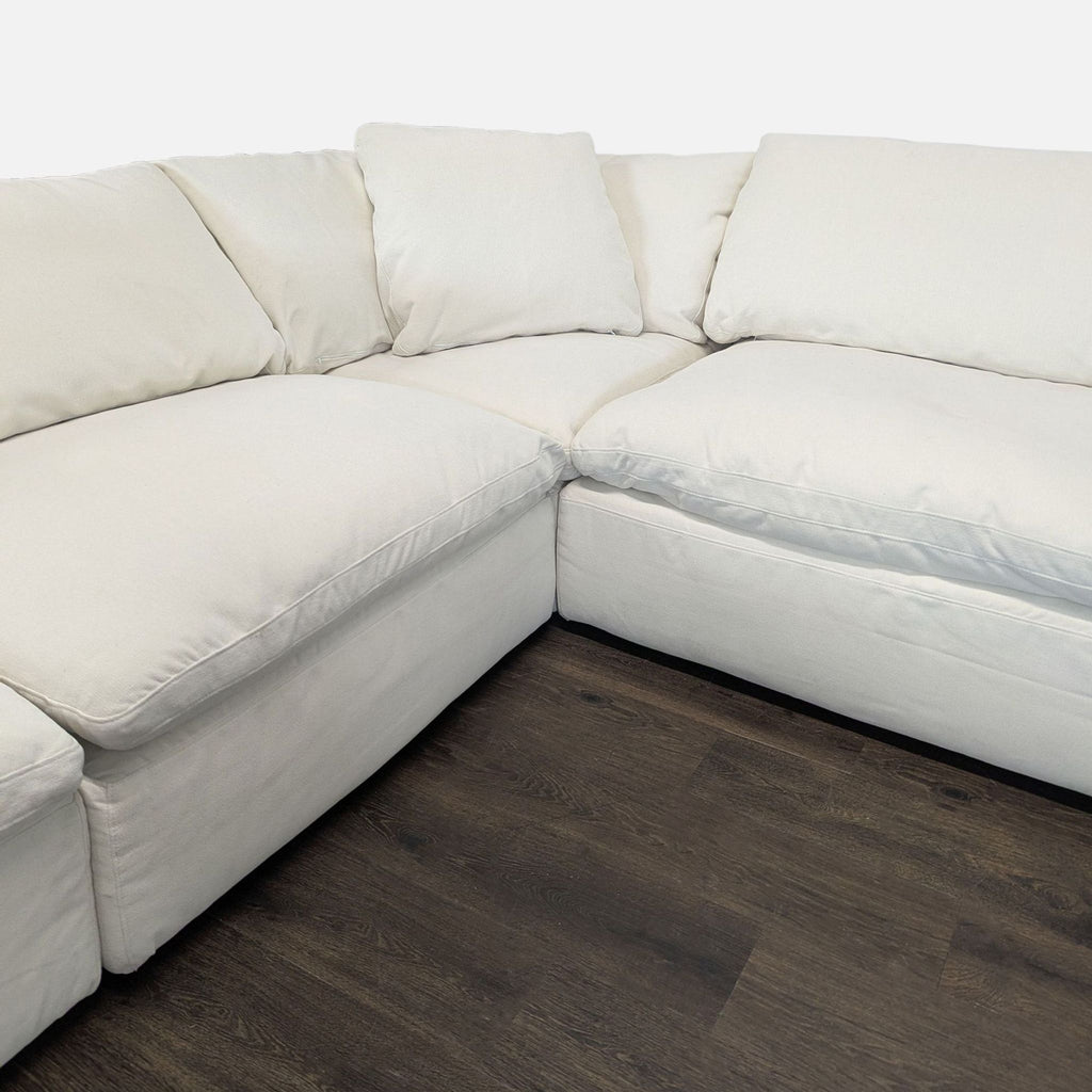 Spacious modern white sectional featuring plush back pillows and a chaise lounge, ideal for family rooms.