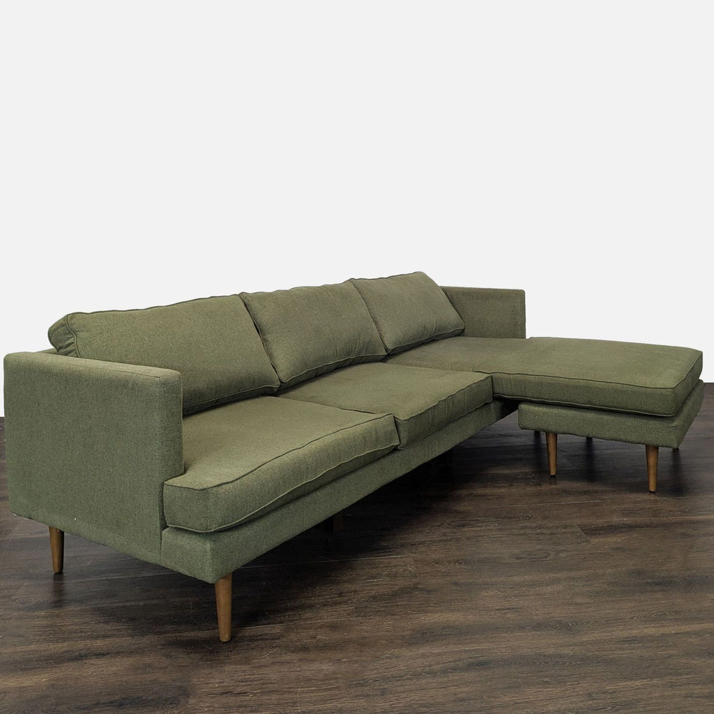 Contemporary Joybird sectional; green upholstery, wooden legs, right chaise design, and plush seat cushions.