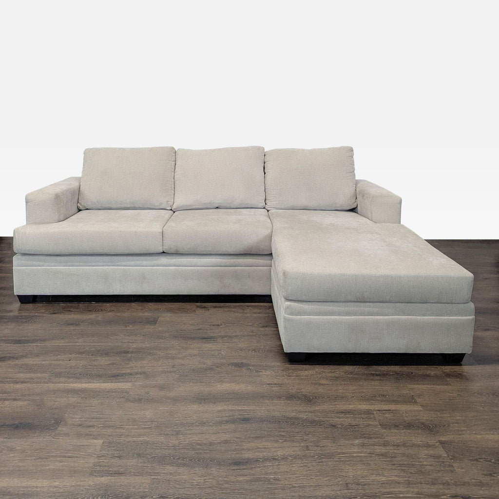 Living Spaces sectional sofa with beige fabric, chaise lounge, modern style, and comfortable plush cushions.  