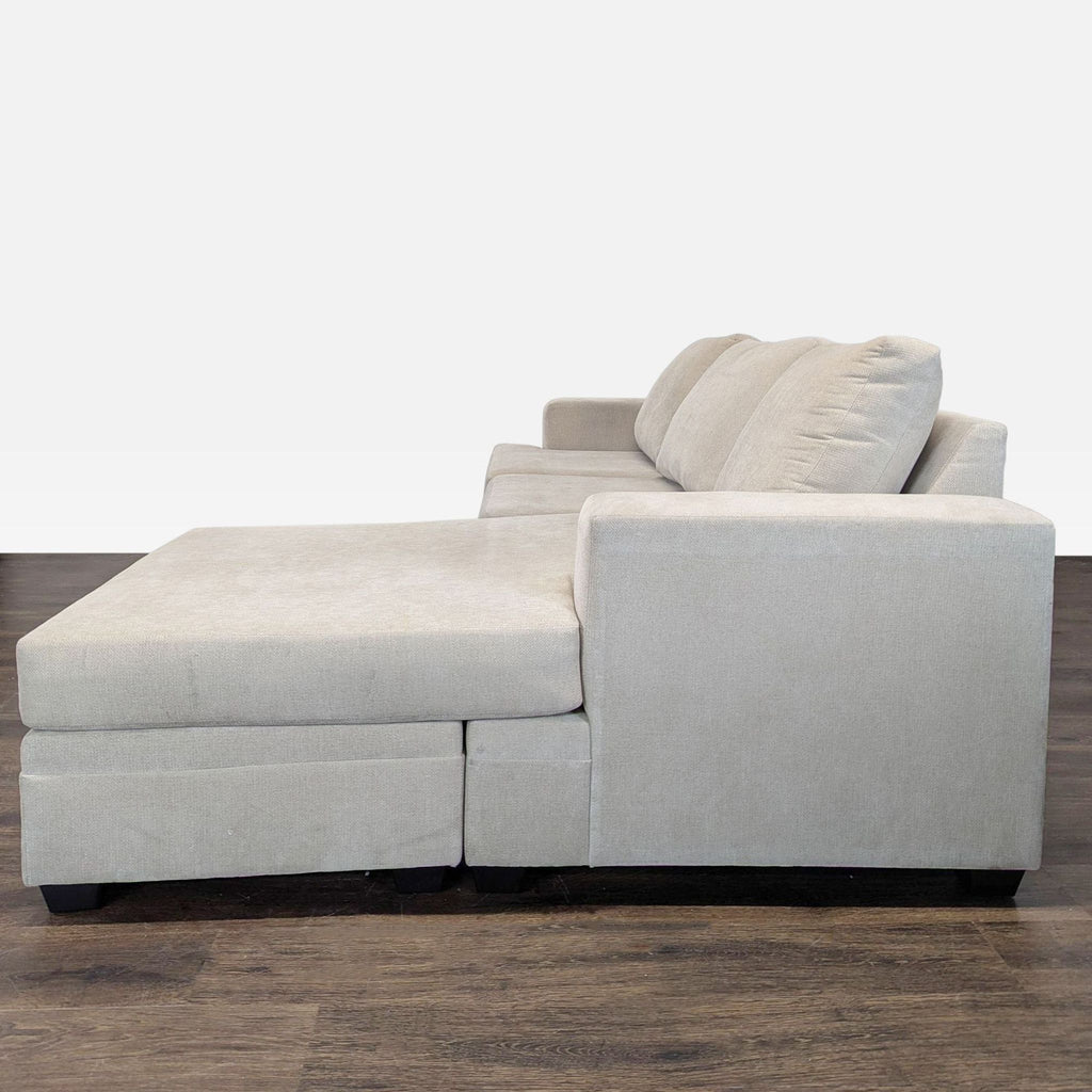 Modern beige sectional sofa by Living Spaces, featuring plush cushions and chaise lounge for extra seating.