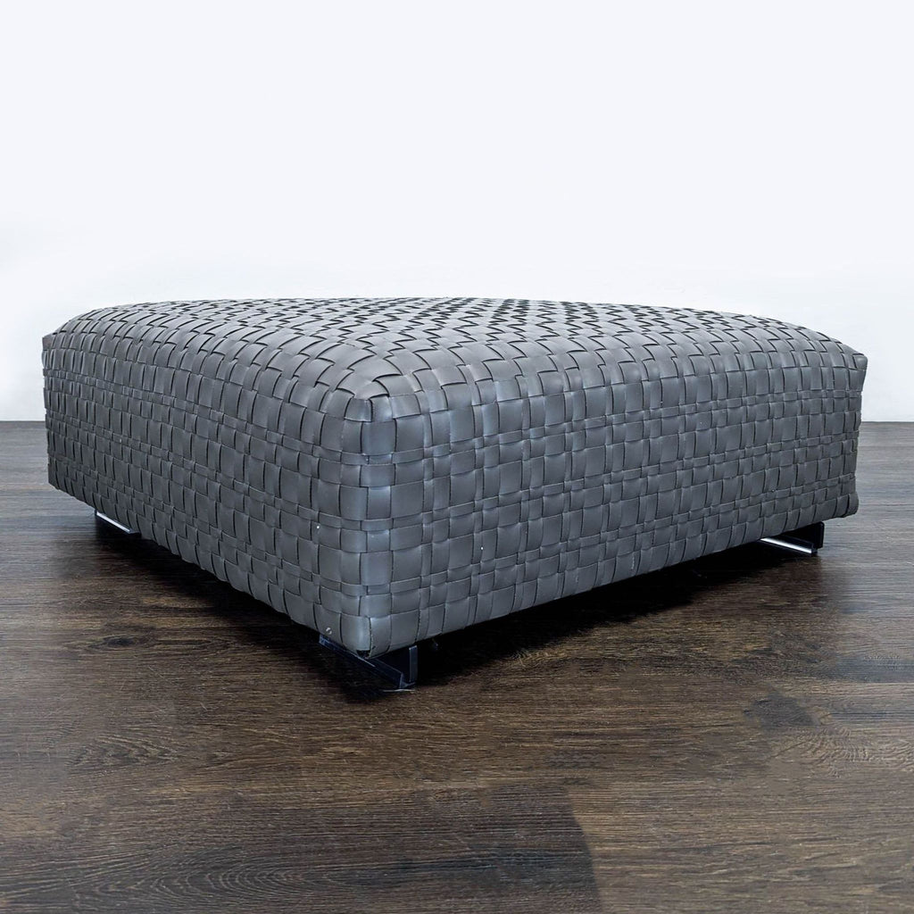 Flexform Bangkok ottoman; contemporary pouf in woven leather, with metal legs and upholstered polyurethane padding.