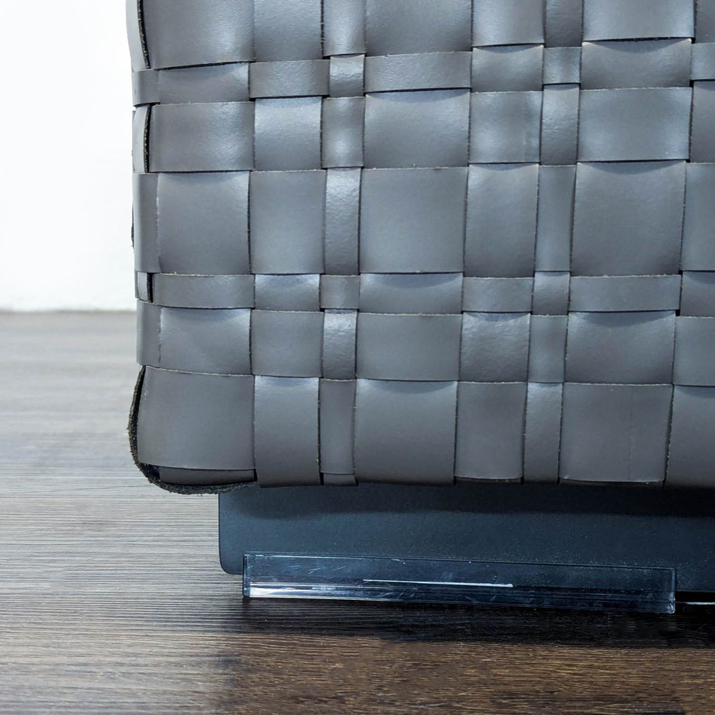 Italian-designed pouf from Flexform, featuring woven leather upholstery, metal feet, and plush padded construction.