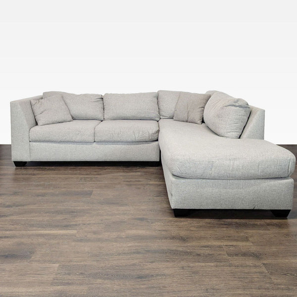 Light gray L-shaped sectional sofa with plush cushions and a wide chaise, perfect for modern living rooms.