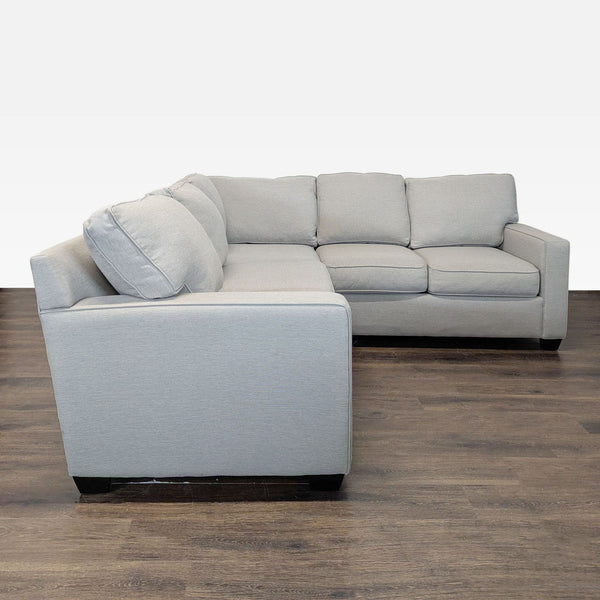 Pottery Barn L-shaped sectional sofa with soft neutral fabric and plush cushions, ideal for living rooms.