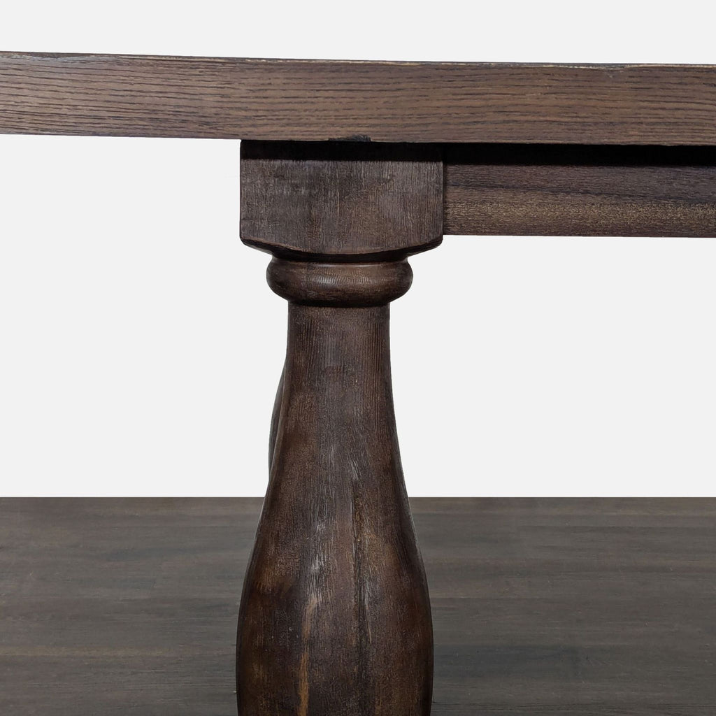 3. Close-up of a sturdy, carved wooden table leg with a rich, rustic finish, part of a dining set.