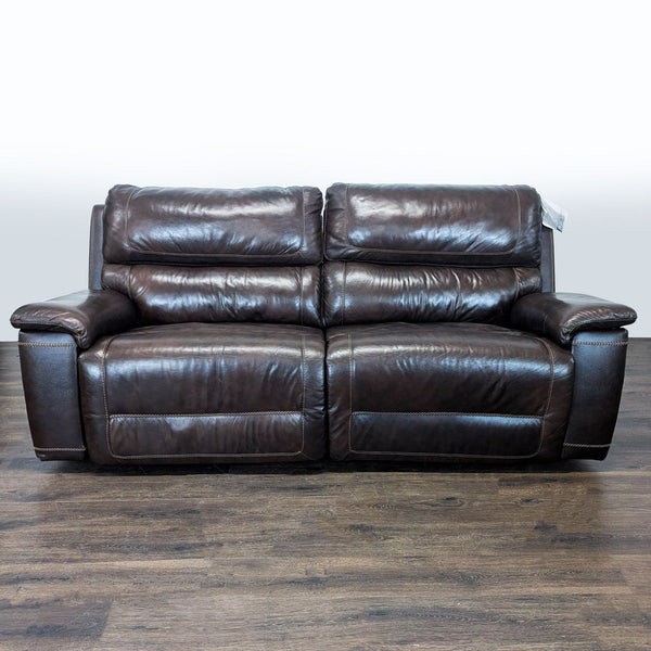 Brown leather reclining loveseat with wide armrests, plush cushions, and elegant, easy-to-clean upholstery.
