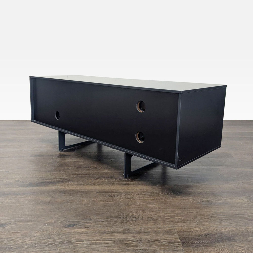 Aura entertainment unit showing visual lightness with steel base, wood contrast, and cabinet by Marti & Delamo.
