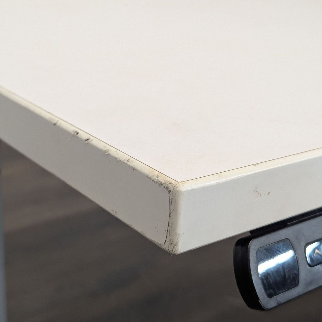 Modern Jarvis desk with sturdy electric frame, white surface, and controls to switch between sitting and standing.